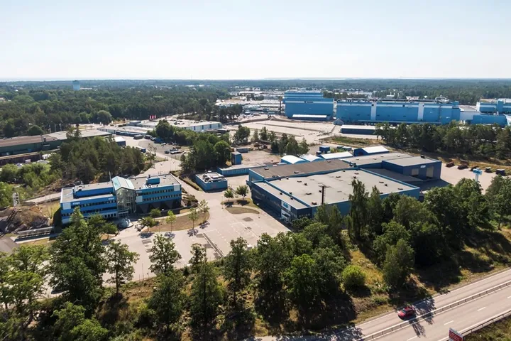 Snickeriet 4 i Oskarshamn från luften: blå industribyggnader omgivna av skog